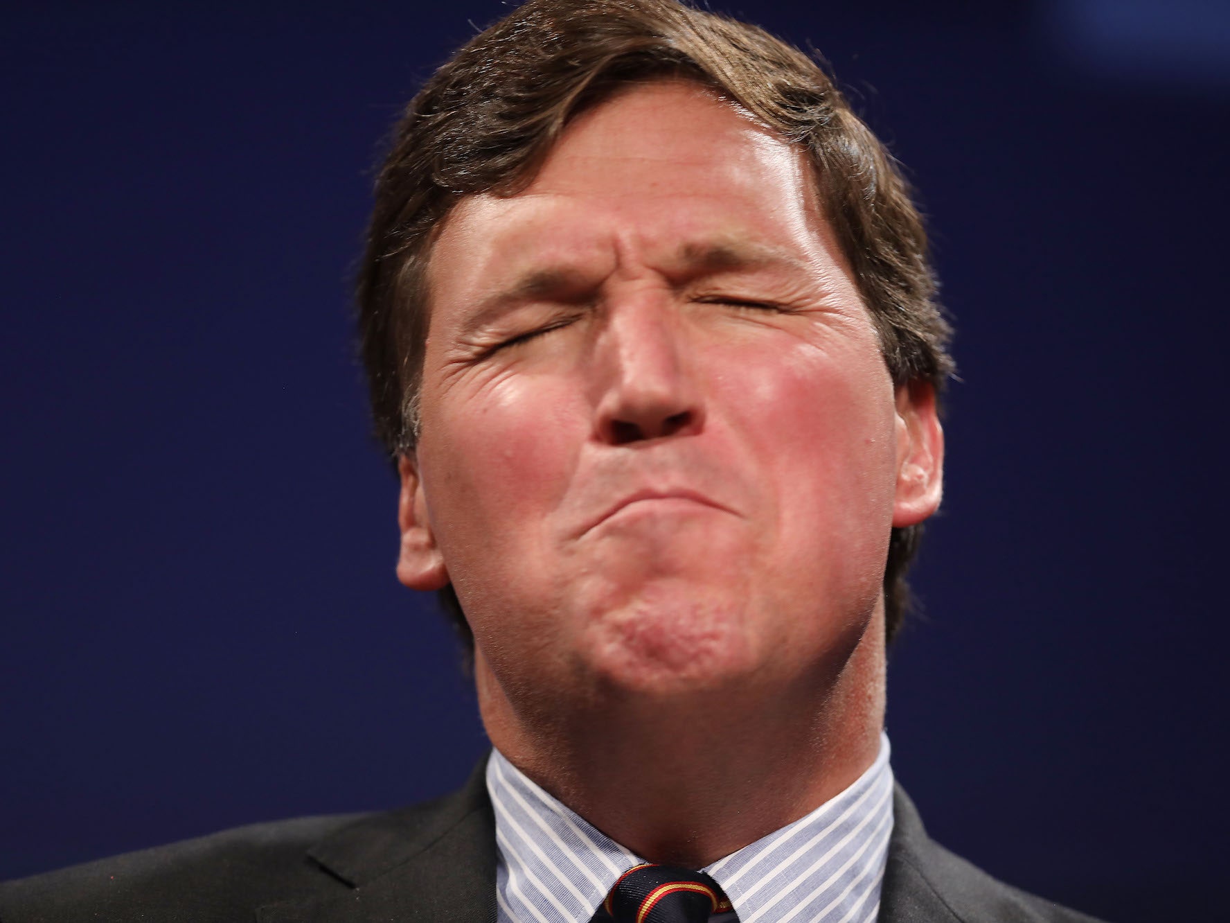 Tucker Carlson, seen here squeezing out this week's new conspiracy theory.